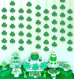 Twelve individual strands of imported Irish party ornaments hung against a wall as a photo booth backdrop.