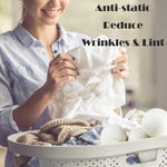 Anti static laundry dryer balls being placed into a washing machine dryer drum for clothing separation.