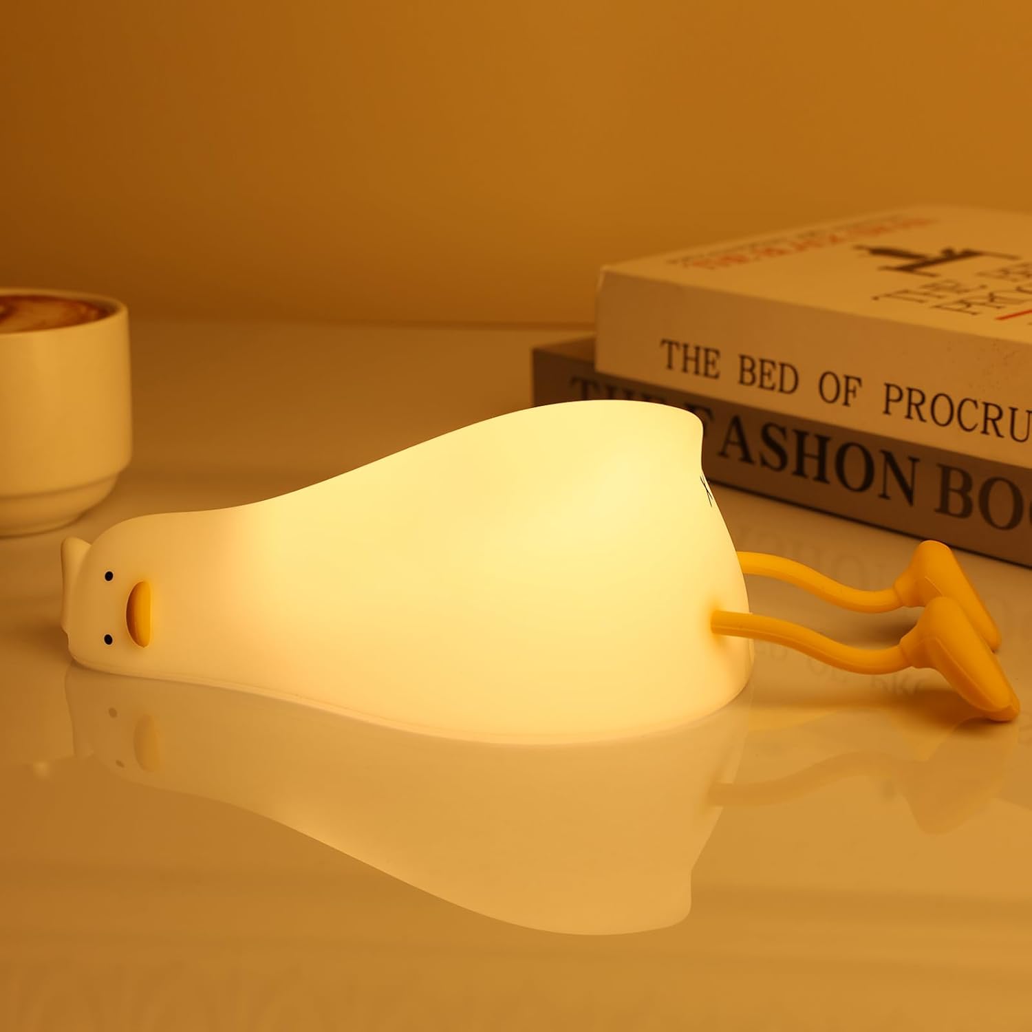 MAGOHMT existential crisis duck lamp front view displaying warm glowing illumination on a bedside table