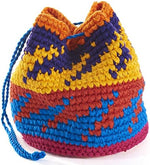 Close-up of the eight unique hand-crocheted miniature footbags displaying their vibrant colors and folk patterns.