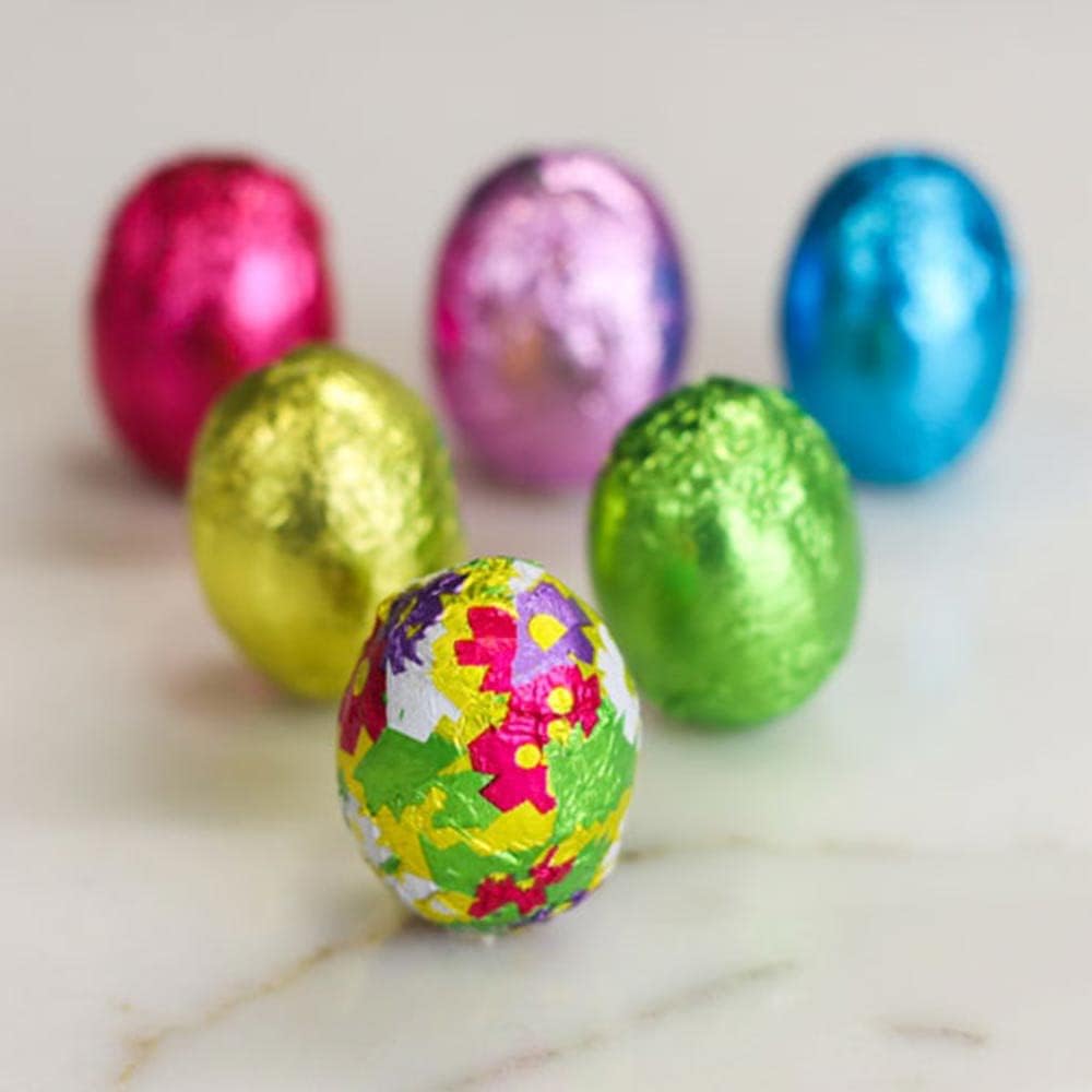 Premium imported USA chocolate mini eggs spread out to show the variety of decorative foil colors.
