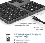 JOYEKY portable Bluetooth numeric pad displayed next to a compact laptop bag demonstrating its lightweight travel design