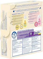 Travel-size baby skincare kit items arranged on a soft surface