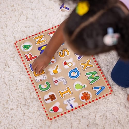 Close up of easy grasp pegs on the Melissa and Doug wooden alphabet board