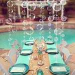 Six foot long white bubble garland strings hanging from a living room ceiling for an ocean theme party