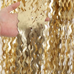 Four pack wavy tinsel streamers hung on a party doorway showing shimmering metallic texture