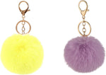 Yecomsy fluffy pom pom keychain attached to a handbag strap.