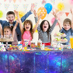 Galaxy theme party table setup with iridescent covers