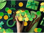 Decorative gold and green coins stored inside a miniature pot of gold.