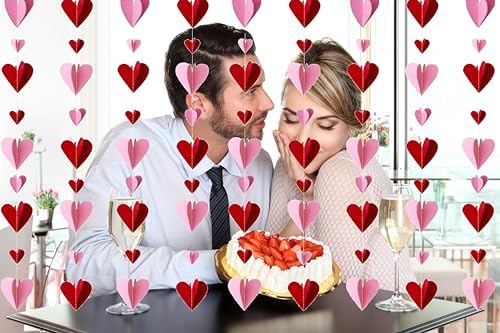 Pre strung red and pink 3D heart paper garlands arranged on a backdrop wall