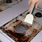 Hand holding Auhsgch scraper cleaning burnt grease off a kitchen stove top