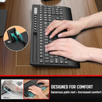 Trueque silent computer keyboard highlighting the built-in phone holder slot with a smartphone placed inside