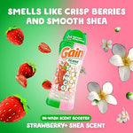 Pouring Gain strawberry and shea scent beads into a washing machine drum