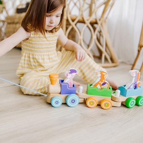 Melissa and Doug wooden toddler pull train with three removable rocking animal figures including a cow pig and horse.