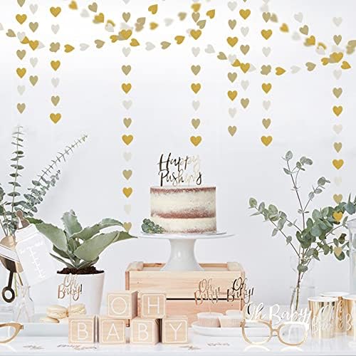 Elegant white and gold heart banner hanging against a neutral wall backdrop for an engagement ceremony.