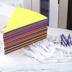 Six sets of vibrant rainbow bunting garland draped across an outdoor carnival setting.