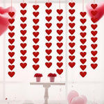 Romantic bedroom setup featuring red heart hanging strings draped over a window frame.