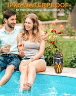 Vanten atmosphere torch lamp speaker set placed on an outdoor patio table during an evening party.