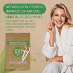 Biodegradable charcoal dental floss sticks showing vegan corn starch handles.