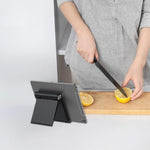 Generic black adjustable tech accessory supporting a large smartphone during a video call