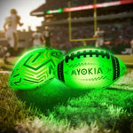 Kids playing outdoor night sports with a red green and blue glowing football
