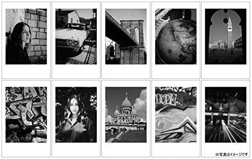 Glossy credit card size monochrome instant photo prints next to camera gear