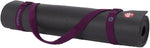 Manduka yoga strap wrapped securely around rolled black mat