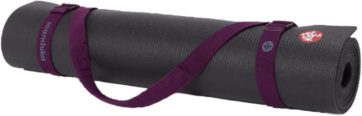 Manduka yoga strap wrapped securely around rolled black mat