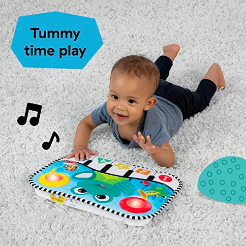 Infant lying on their stomach during tummy time interacting with the colorful lights of the Baby Einstein musical learning mat.