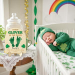 Instructional view of stamping a newborn baby foot onto the green clover keepsake board