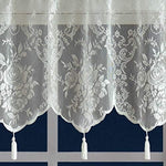 Detailed shot of the scalloped edge and decorative hanging tassels on the ivory lace curtain