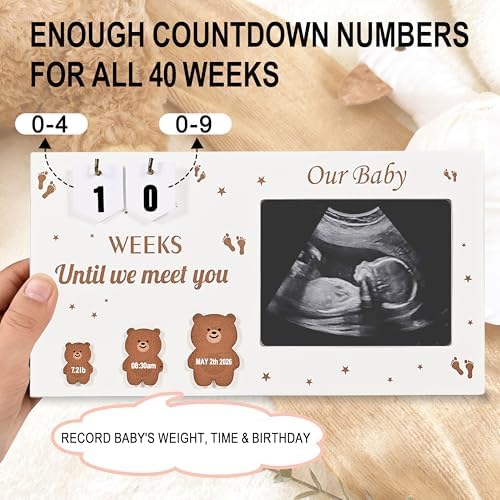 Wooden baby milestone frame with inkless newborn handprint kit and decorative cards laid out.