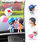 Cute couple figurine with balloon on car dashboard