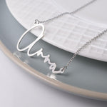 PicturesOnGold personalized script necklace laid flat on surface