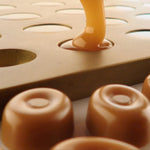 Close-up of golden hard caramel candies on a display surface