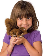 Folkmanis red squirrel wildlife puppet resting in the palm of a hand showing scale and portability.