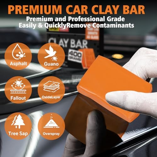 Using orange clay bar cleaner kit on a car glass windshield with detailing spray lubricant.