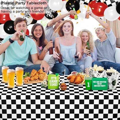 Full setup of racing themed birthday party supplies featuring checkered plastic tablecloths.
