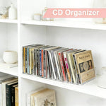 Clear acrylic desk organizer holding music CDs and movie boxes in a room