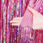Two pack metallic pink party streamers installed on a living room wall for a bachelorette party
