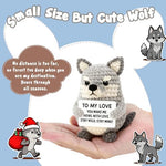 Close up of crochet wolf plush holding love message sign