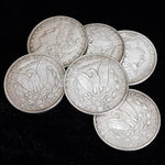 Magician holding replica Morgan Dollar coins for sleight of hand performance