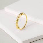 Close up of movable spinning beads on gold plated ring