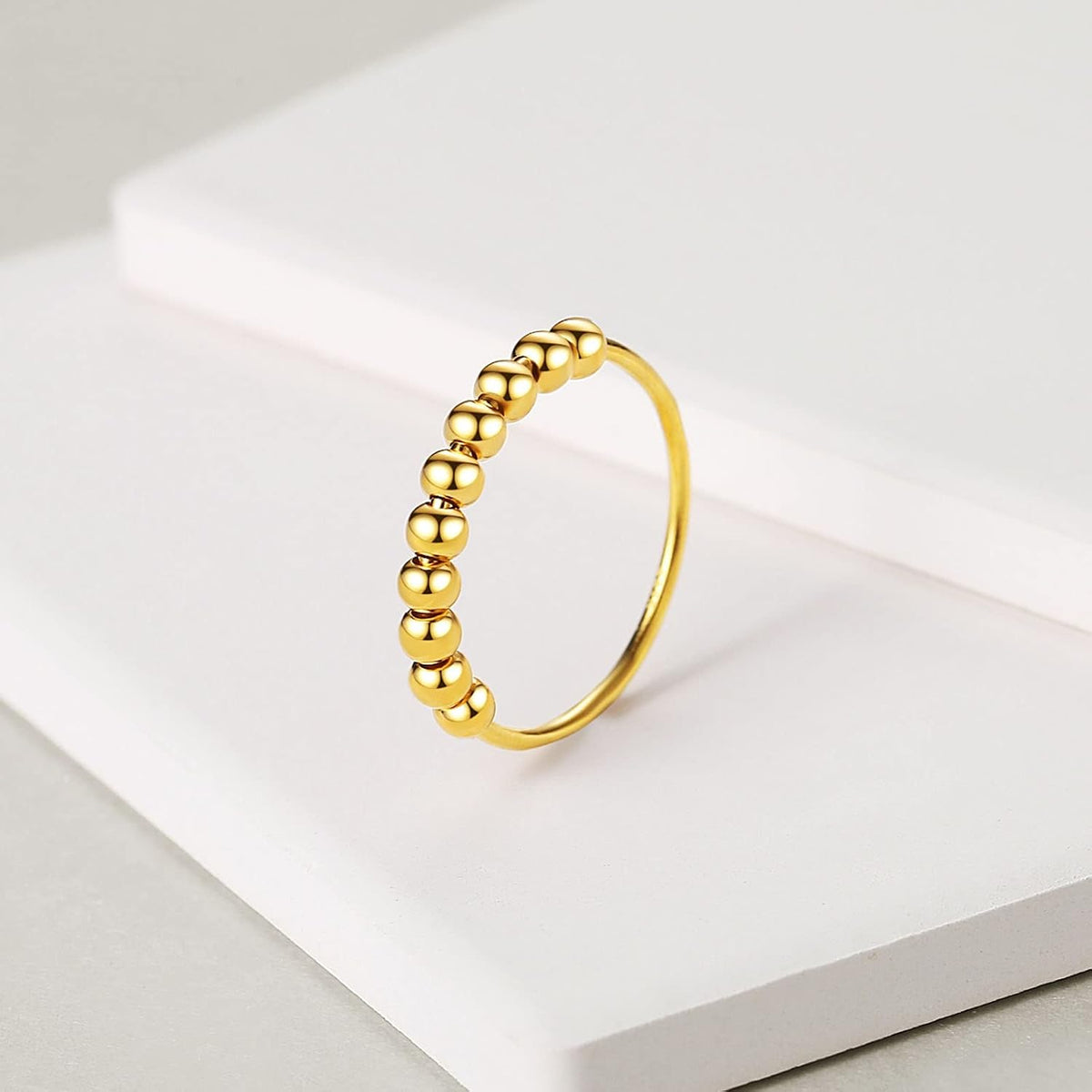 Close up of movable spinning beads on gold plated ring