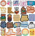 Close up view of several motivational quote decals personalizing the top lid of a modern silver laptop computer.