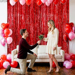 Two pack of KatchOn red tinsel backdrop curtains installed on a party doorway.