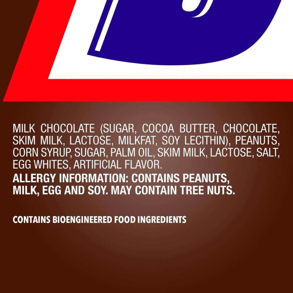 A close-up view of a cut Snickers mini chocolate bar displaying layers of peanuts, caramel, and fluffy nougat.