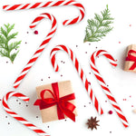 Yumzo holiday candy canes bulk set displayed in its seasonal winter themed two tier gift box packaging.