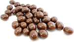 Premium imported chocolate coffee dragees spilled out of packaging close up view.