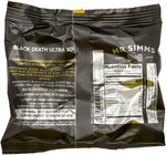 Two pieces of black death mega ultra sour hard candy balls showcasing the intense acid coating.